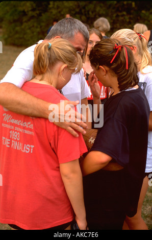 Coach comforting crying runners after losing race age 40 and 16. St Paul Minnesota USA Stock Photo
