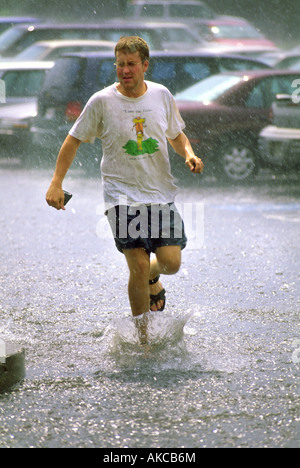 A man runs through a summer downpour Stock Photo
