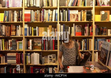 Surrounded by books a young 12 year-old girl intently browses Art books in Borders bookshop in Central London England Stock Photo