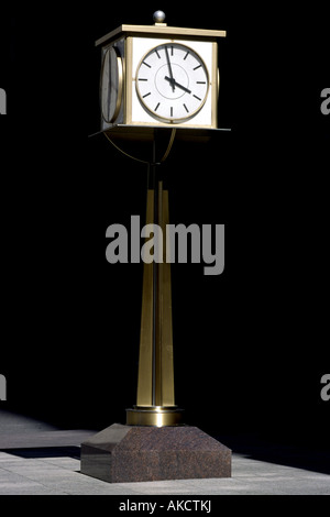 Public clock on a pedestal against a black background Stock Photo