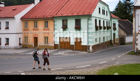 Two hikers walking through village of Rejstejn Czech republic Stock Photo