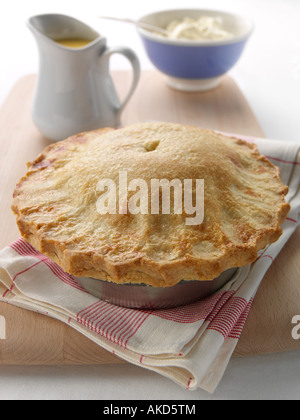 A whole apple pie with custard and thick double cream editorial food Stock Photo