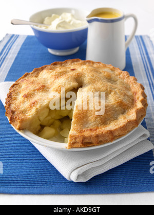 A whole apple pie open with custard and thick double cream editorial food Stock Photo