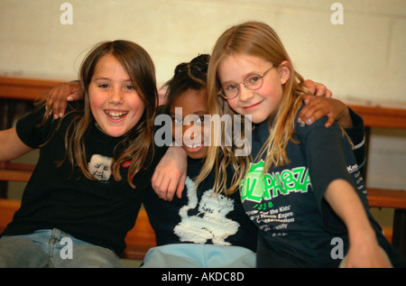Interracial friends age 12 happily embracing at community youth center. St Paul Minnesota USA Stock Photo