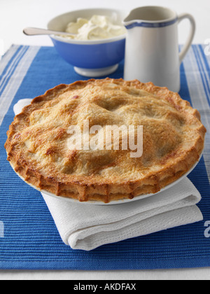 A whole apple pie with custard and thick double cream editorial food Stock Photo