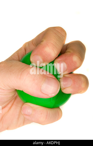 A stock photograph of a man's hand squeezing a green stress ball. Stock Photo