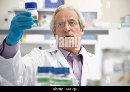 Scientist looking at specimen bottle in laboratory Stock Photo