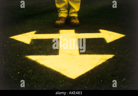 one persons feet standing by direction arrows Stock Photo
