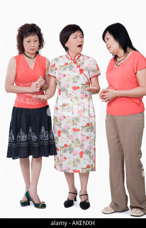 Two senior women and a mature woman standing together and talking Stock Photo