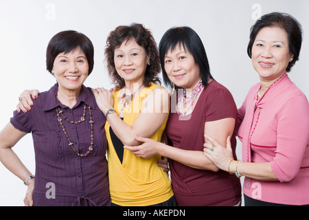 Portrait of three senior women and a mature woman standing together and smiling Stock Photo