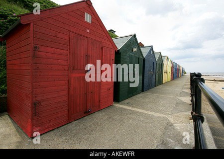 A line of brightly painted beach huts stretching along the promenade Mundesley 'North Norfolk' UK Stock Photo