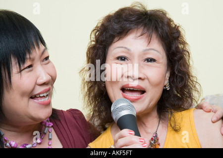 Portrait of a senior woman singing with a mature woman in front of a microphone Stock Photo