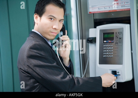 Portrait of a businessman talking on a public phone Stock Photo