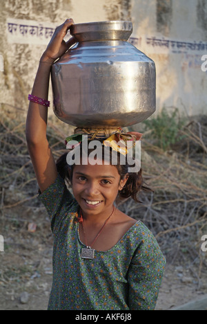 Girl carrying a water jug on her head in Rajasthan India Stock Photo