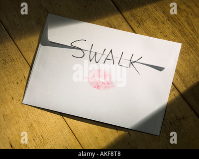 An envelope with SWALK Sealed With A Loving Kiss on the back and a pair of rosy lips Stock Photo