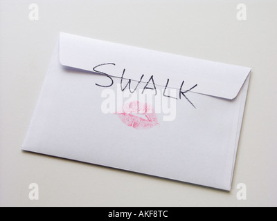 An envelope with SWALK Sealed With A Loving Kiss on the back and a pair of rosy lips Stock Photo