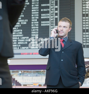 Businessman standing at an airport talking on a mobile phone Stock Photo