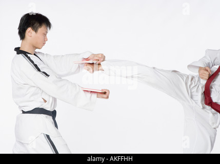 Low section view of a mid adult man practicing kickboxing with a young man Stock Photo