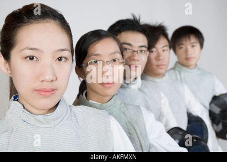 Portrait of two young women and three young men in a row Stock Photo