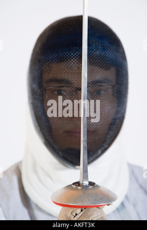 Portrait of a man wearing a fencing mask and holding a fencing foil Stock Photo