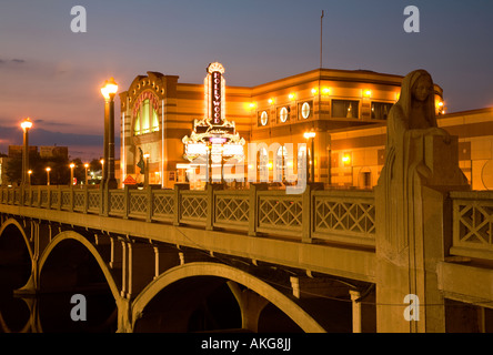 ILLINOIS Aurora Stone statue of woman on bridge over Fox River at dusk lights on Hollywood casino building exterior Stock Photo