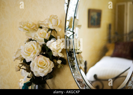 Detail of with white roses next to antique vanity mirror. Stock Photo