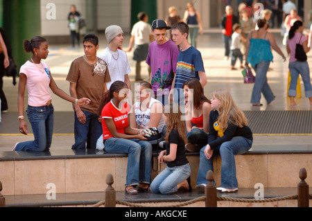 A GROUP OF TEENAGE BOYS AND GIRLS SITTING IN A SHOPPING ARCADE UK Stock Photo