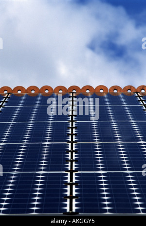 Photovoltaic cells (solar panels) on the roof of a house to produce electricity. Stock Photo