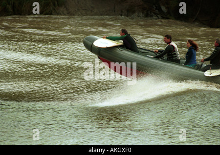 A boat riding the Severn bore wave at Minsterworth, UK. Stock Photo