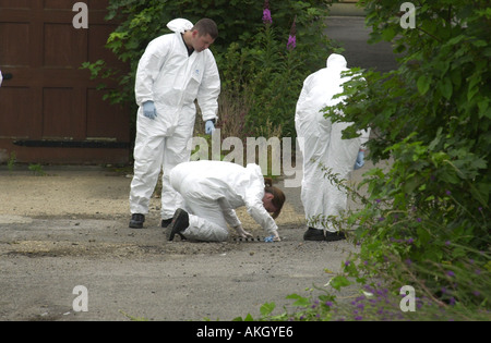 Police officers examine a crime scene UK Stock Photo