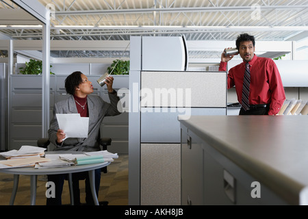 Two office workers using a tin can telephone Stock Photo
