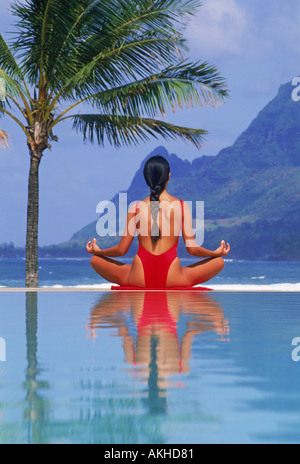 Woman doing yoga at Hanalei Bay poolside on Island of Kauai Stock Photo