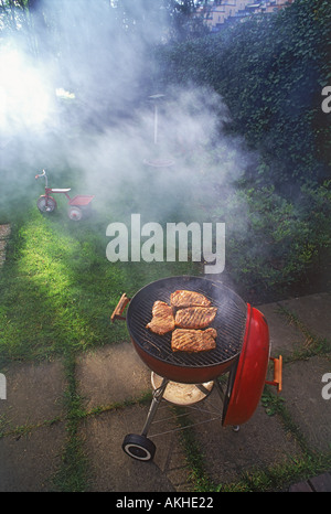Steaks and smoke on backyard barbeque Stock Photo