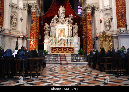 Nuns during afternoon Vesper in church Santa Maria della Salute,  Venice Italy Stock Photo