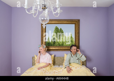 Couple in bed with cellphones Stock Photo