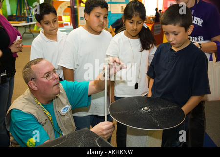 ILLINOIS Aurora Students experiment with exhibits in Sci Tech Hands on Museum interior male adult demonstrate sound waves Stock Photo
