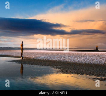 Antony Gormley Iron man statue on Crosby beach, Sefton, Merseyside Uk, at sunrise. With previous nights snow. Stock Photo