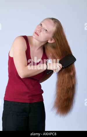Young woman brushing her very long red hair Stock Photo