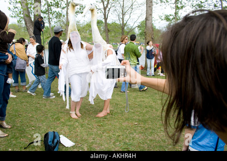 Photographer capturing two actors in geese costumes. MayDay Parade and Festival Powderhorn Park. Minneapolis Minnesota USA Stock Photo