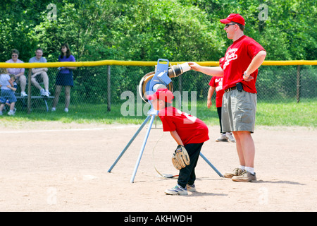 A Softball pitching machine being used at a practise session Stock Photo