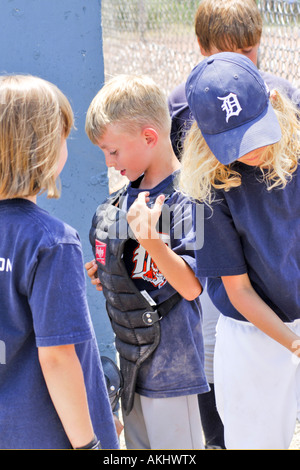 Young 6year old male being suited up as a catcher at a softball game Stock Photo