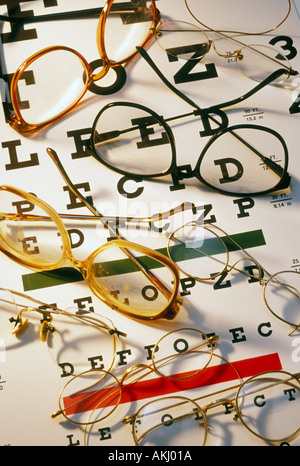 assorted eye glasses on eye chart Stock Photo