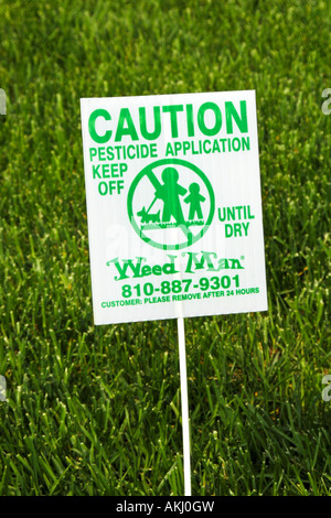 Caution sign on a lawn that has just been sprayed with pesticides Stock Photo