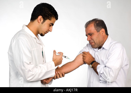 Male patient having injection from male doctor Stock Photo