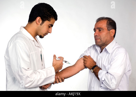 Male patient having injection from male doctor Stock Photo