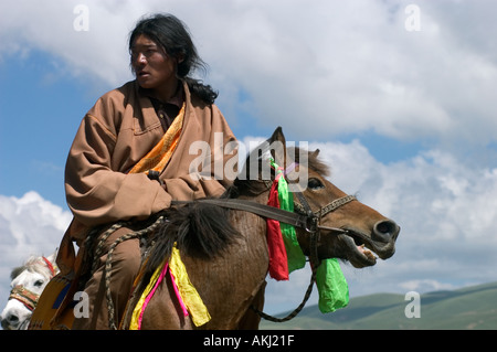 Khampas the warrior horseman of old Tibet compete at the Litang Horse Festival Kham Sichuan Province China Tibet  Stock Photo