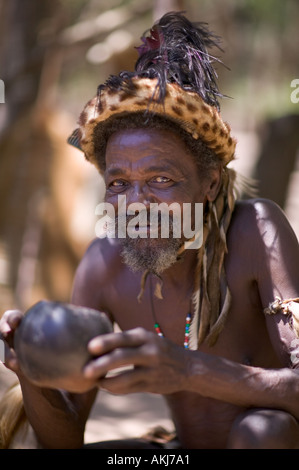 Zulu chief in ceremonial dress sitting next to pot of traditional Stock ...