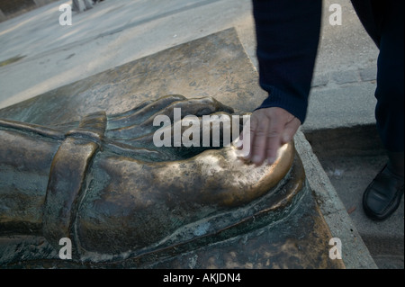 An old Croat woman touches big toe of the statue of Gregorius Nin or Grgur Ninski by Ivan Mestrovic, Split, Dalmatia, Croatia, E Stock Photo