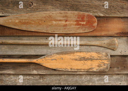 Three wooden paddles hanging on wood siding Stock Photo