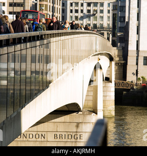 Going to work early morning workers crossing London Bridge No model release required as crowd faces small and indistinct Stock Photo
